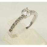 A DIAMOND RING, the claw set brilliant cut stone of approximately 0.39cts to plain shoulders each