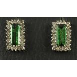 A PAIR OF TOURMALINE AND DIAMOND EAR STUDS, the facet cut oblong tourmalines claw set to borders