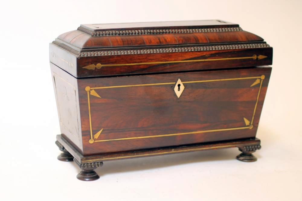 A REGENCY ROSEWOOD TEA CHEST of sarcophagus form with brass stringing and reel edging, hinged lid