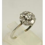 A DIAMOND CLUSTER RING, the central claw set brilliant cut stone of approximately 0.25cts to a