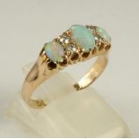 A VICTORIAN OPAL AND DIAMOND RING, the three cabochon polished opals claw set with four small old