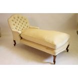 A VICTORIAN WALNUT FRAMED DAY BED button upholstered in a cream ribbed weave, arched back, shaped