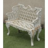 A CAST IRON GARDEN BENCH, the pierced trellis back with scrolled top rail centred by a shell,