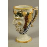 A STAFFORDSHIRE PORCELANEOUS BACCHUS MASK FROG MUG, c.1800, of typical form with earred "S" scroll