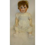 An Ernst Heubach bisque head character doll with brown glass sleeping eyes, open mouth and teeth,