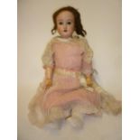 A Schoenau & Hoffmeister bisque head doll with brown glass sleeping eyes, open mouth and teeth,