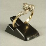 A VICTORIAN TWO STONE DIAMOND RING, the brilliant cut stones claw set in a cross-over setting to