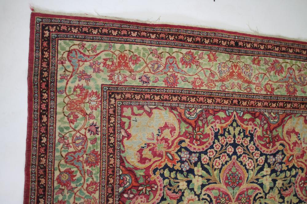 A KERMAN RUG, the navy blue field with foliate scrolls centred by a raspberry flowerhead gul, - Image 4 of 6
