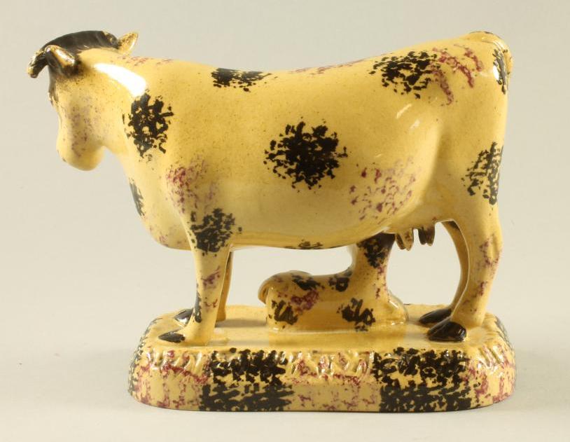 AN ENGLISH BUFF GLAZED EARTHENWARE MODEL OF A COW AND CALF, early 19th century, the horned cow - Image 2 of 3