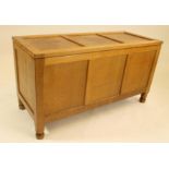 A MALCOLM PIPES ADZED OAK PANELLED COFFER, the hinged lid with three panels, similar fascia,