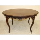 A VICTORIAN ROSEWOOD CENTRE TABLE, the moulded edged oval top on scroll edged and waved frieze