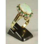 AN OPAL, EMERALD AND DIAMOND COCKTAIL RING/PENDANT, the oval cabochon polished opal claw set to an