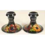 A PAIR OF MOORCROFT POTTERY DWARF CANDLESTICKS, mid 20th century, the bell shaped sockets issuing