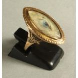 A GEORGIAN "EYE" RING, the eliptical ivory panel painted with a blue eye in a plain unmarked gold