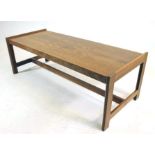 A GORDON RUSSELL TEAK COFFEE TABLE of oblong form with raised ends, on chamfered square section legs