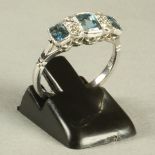 AN ART DECO STYLE AQUAMARINE AND DIAMOND RING, the three oblong cut aquamarines open back collet set