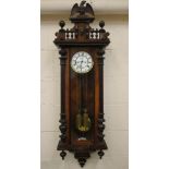 A WALNUT CASED VIENNA TYPE WALL CLOCK, the twin train weight driven movement with two piece white