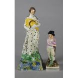 A PEARLWARE FIGURE, early 19th century, modelled as Ceres standing holding a sheaf of corn and a