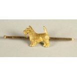 A 9CT GOLD TIE PIN centred by a terrier, 2.9g