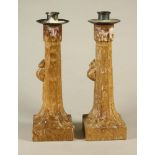 A PAIR OF ROBERT THOMPSON OAK CANDLESTICKS, the circular metal sconce on stepped faceted tapering