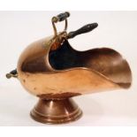A VICTORIAN COPPER COAL SCUTTLE of helmet form, the loop handles with turned ebonised grips, on