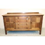 AN OAK SIDEBOARD in the manner of Robert Thompson, the canted top with ledge back, four central
