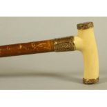 A GENTLEMAN'S EDWARDIAN MALACCA WALKING STICK, the polished ivory "T" shaped handle with scroll