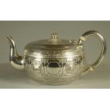 A VICTORIAN SILVER INDIANESQUE TEAPOT, maker George Fox, London 1877, of cushion form, the hinged