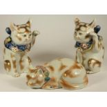 A PAIR OF JAPANESE PORCELAIN CATS, early 20th century, each with a raised left paw, wearing a