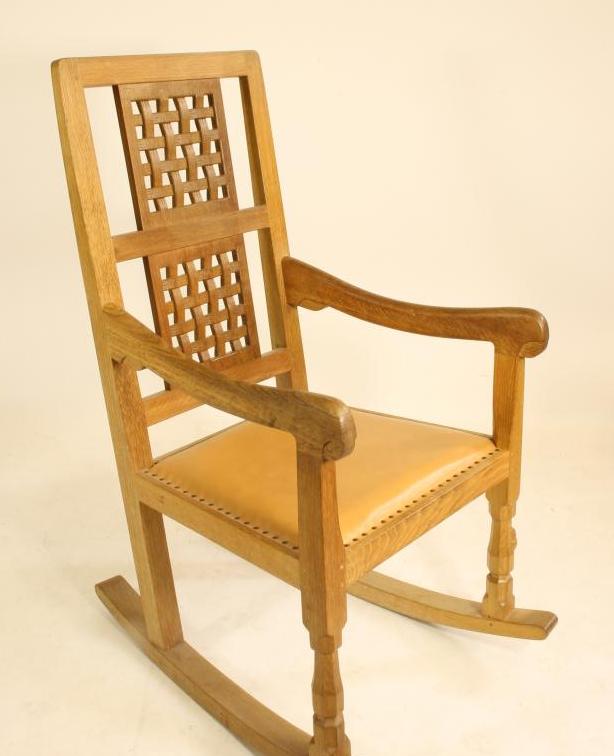 A ROBERT THOMPSON OAK ROCKING CHAIR, the tapering back with straight top rail over two pierced