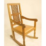 A ROBERT THOMPSON OAK ROCKING CHAIR, the tapering back with straight top rail over two pierced