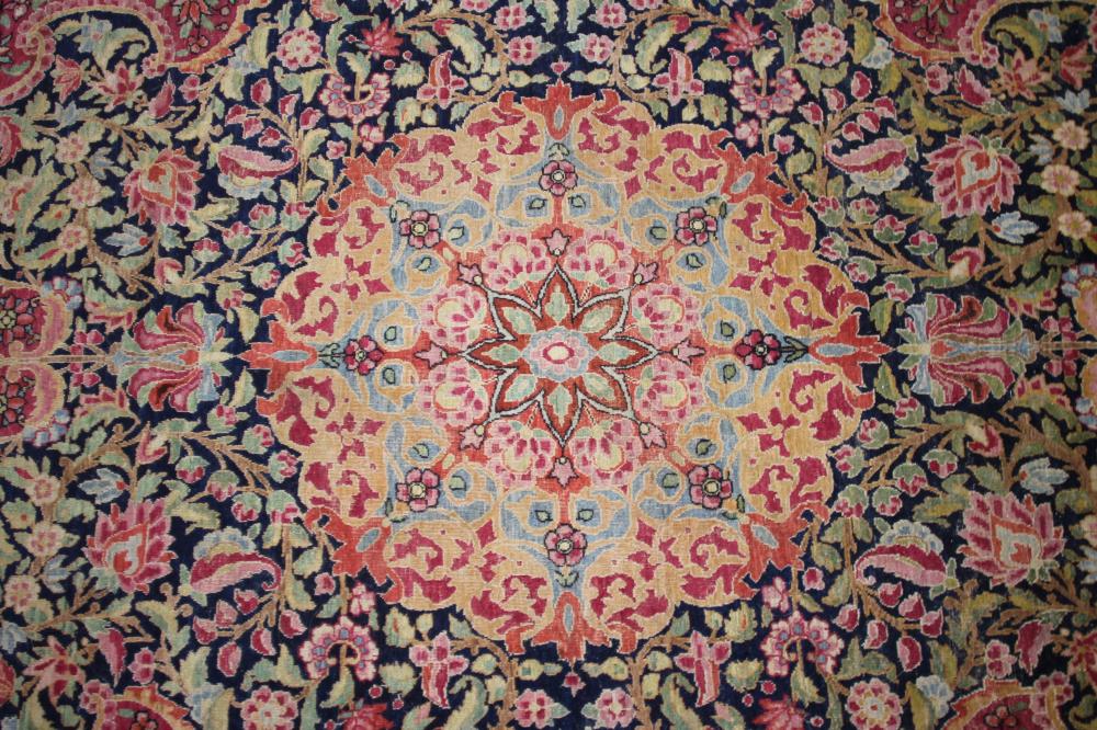 A KERMAN RUG, the navy blue field with foliate scrolls centred by a raspberry flowerhead gul, - Image 3 of 6