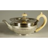 A LATE VICTORIAN SMALL SILVER TEAPOT, maker's mark indistinct, London 1884, of semi fluted squat