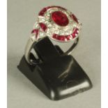 AN ART DECO STYLE RUBY AND DIAMOND PLAQUE RING, the oval panel centrally set with an oval facet