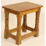 A MALCOLM PIPES OAK STOOL of rounded oblong form with burr oak top, raised on turned faceted and