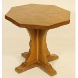 A ROBERT THOMPSON ADZED OAK COFFEE TABLE, of waved octagonal form, the cruciform support with carved