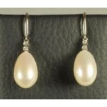 A PAIR OF PEARL DROP EARRINGS, the oval pearls peg set to 18ct white gold mounts each open back