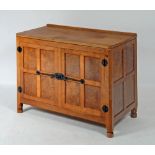 A MALCOLM PIPES ADZED OAK AND BURR OAK SIDE CABINET of canted multi panelled form, the moulded edged