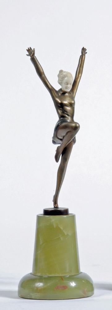 AN ART DECO BRONZE FIGURE OF A YOUNG FEMALE with carved ivory head, standing on her left leg with