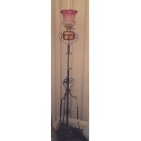 Wrought iron standard lamp with cranberry glass shade