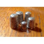 Four silver thimbles and an unmarked child's thimble