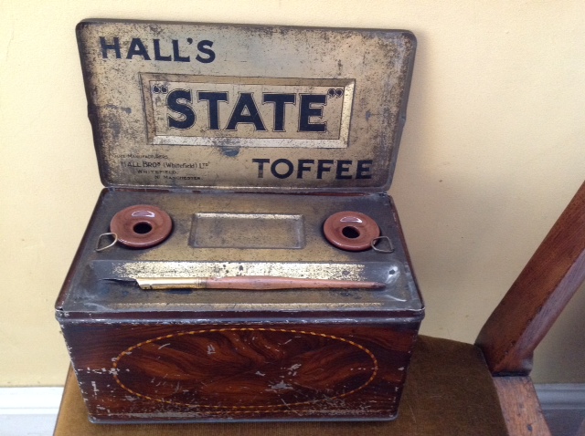 Hall's State toffee tin with lid opening to inkstand, 2 ceramic wells, and a pen all decorated in