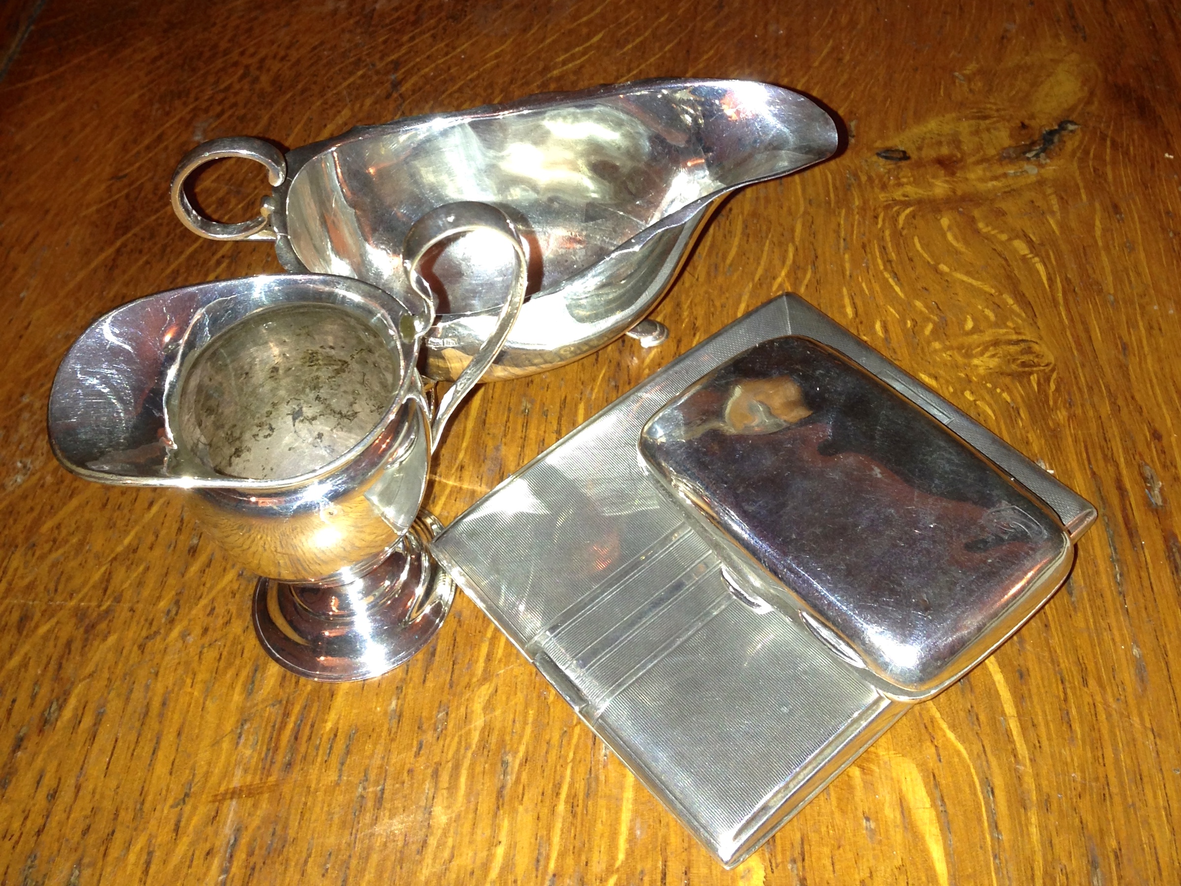 Two silver creamers and two silver cigarette cases