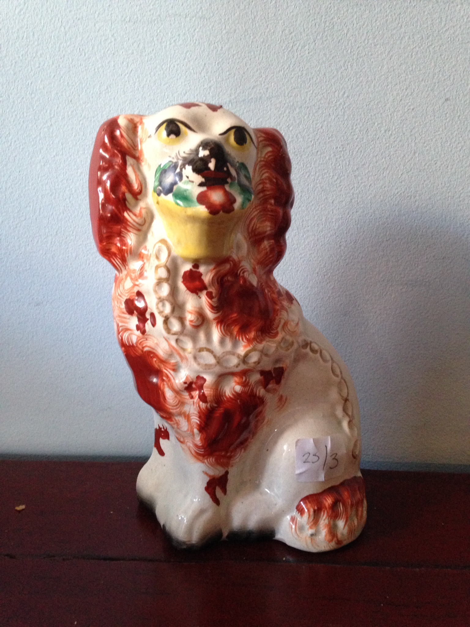 A 19th c Staffordshire dog with basket in mouth 20cm high