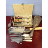 An assortment of plated and silverware inc. hairbrush mother of pearl handled knives etc.