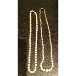 Two ropes of pearls one 18ct and one 9ct gold clasp