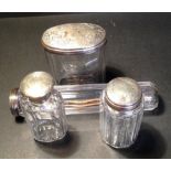 Four matching silver topped dressing table bottles