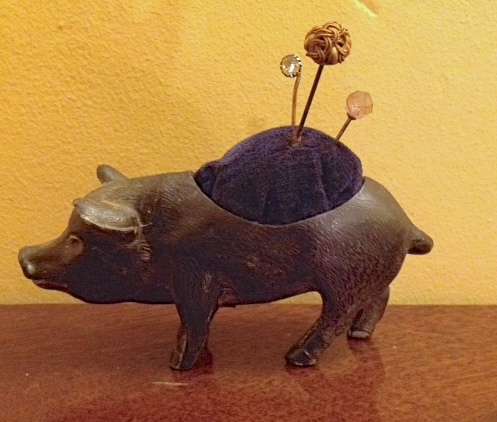 Base metal pincushion in the form of a pig and three pins