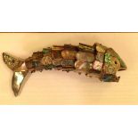 An ornamental fish bottle opener having a reticulated body decorated with abalone panels