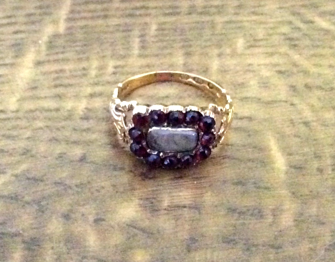 An 18ct gold and garnet mourning ring with hair decoration size O